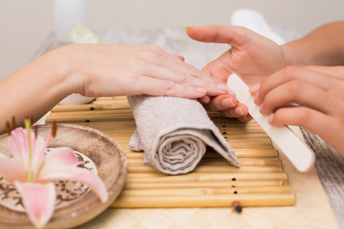 Nail technician giving customer a manicure